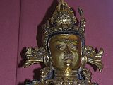 British Museum Top 20 Buddhism 16-2 Vajrasattva Close Up 16. Vajrasattva  Nepal, 15C AD, 52cm high. Here is a close up of Vajrasattva holding the vajra and bell in his hands, has elaborate jewelry, and is inset with semi-precious stones. In Vajrasattva's crown is the seated figure of the Akshobhya, the Tathagata Meditation Buddha of the East.